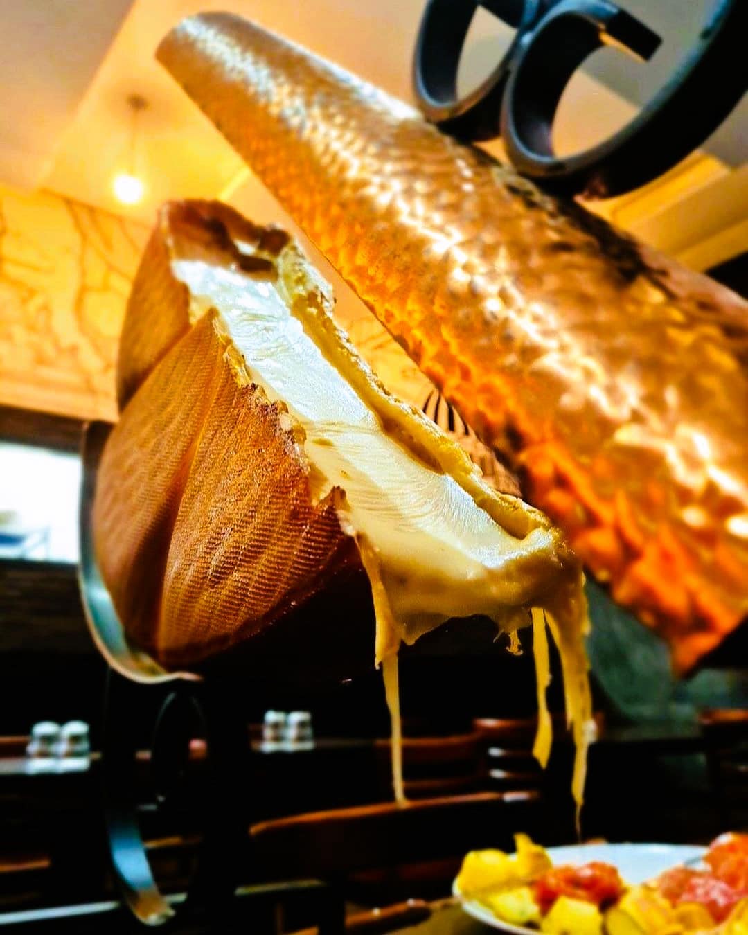 Raclette cheese melting under a heater 44