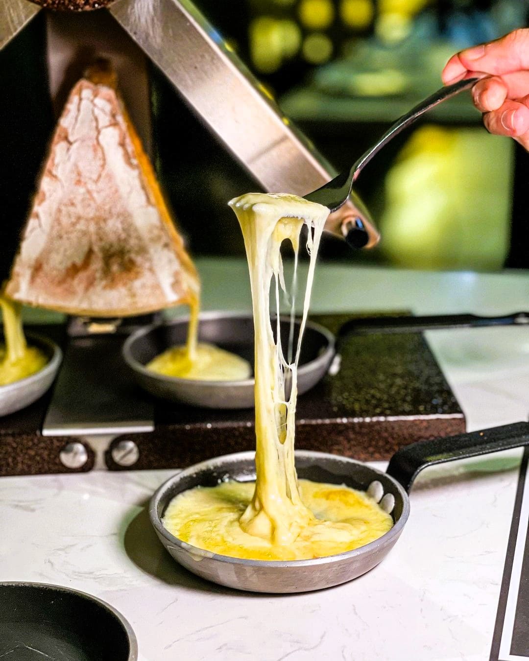 Spooning runny raclette cheese 69