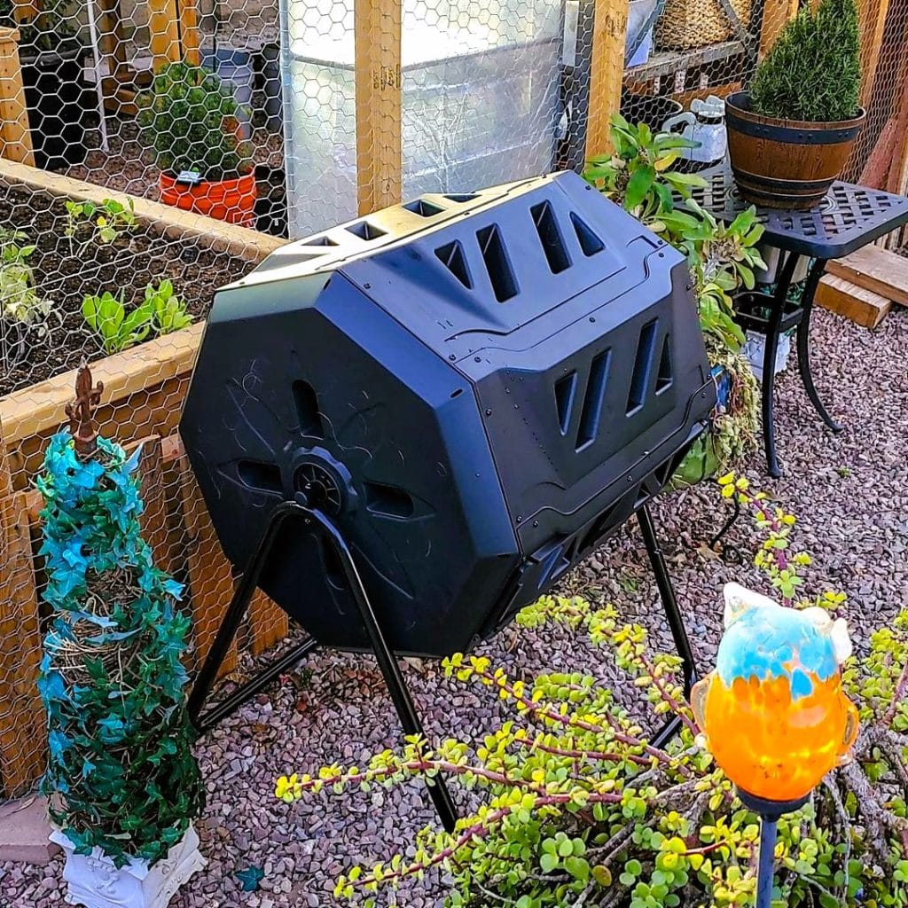Compost tumbler outside the wooden planter 754